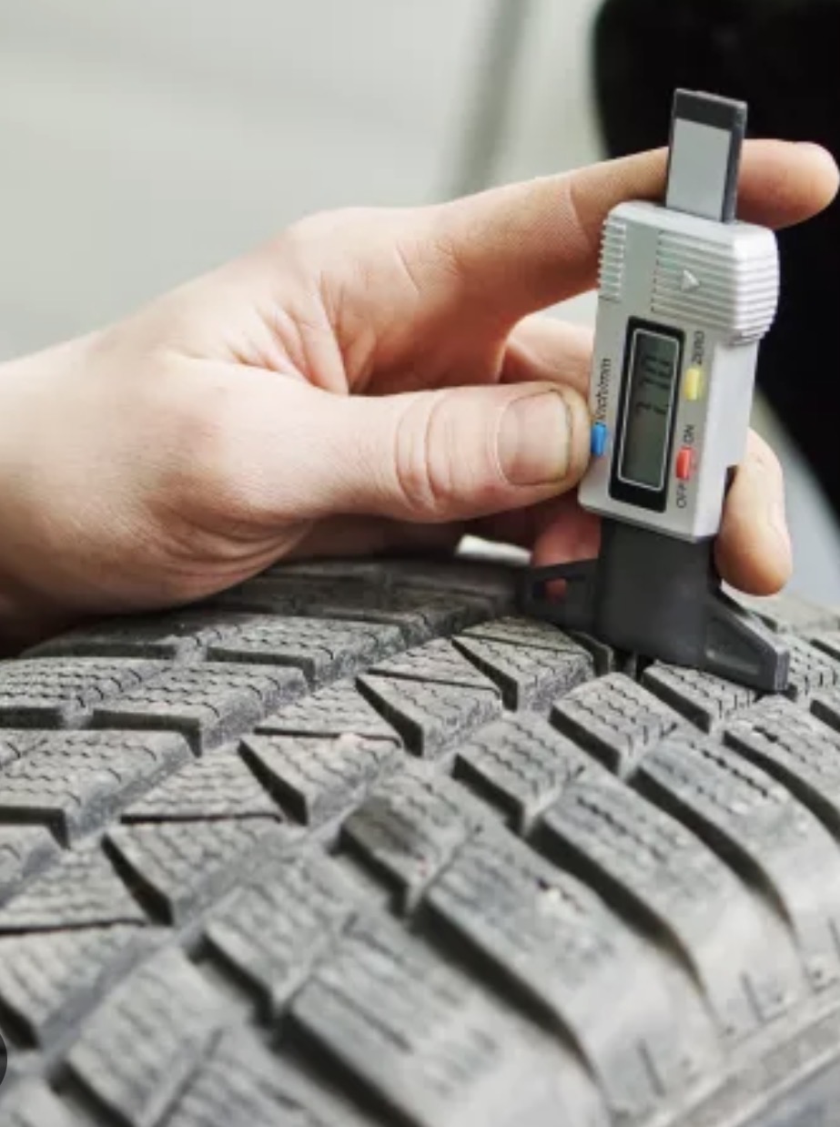 Digital tread depth gauge measuring the tread on a car tyre