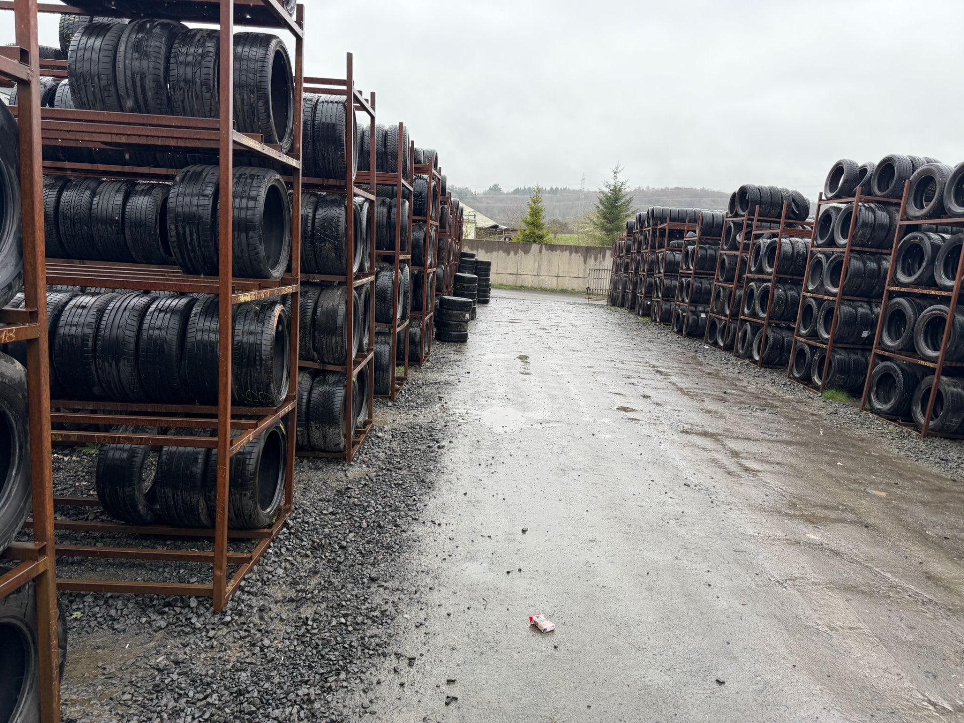 A2Z Tyre Recycling yard with long rows of tyre racks on a rainy day